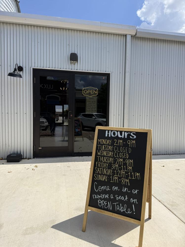 The Board Game Vault front entrance with the hours sign