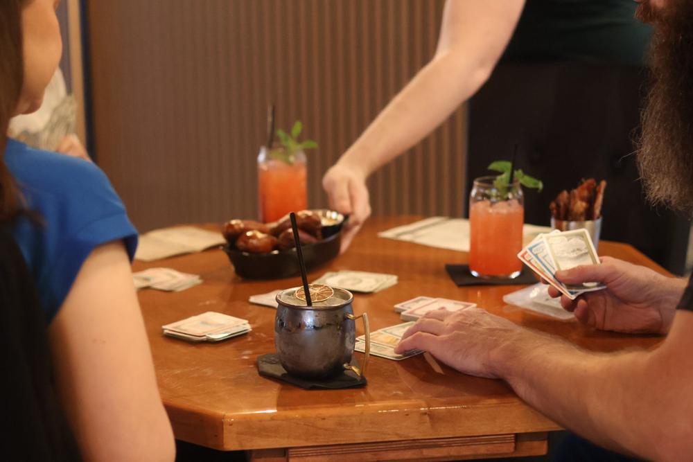 A server bringing drinks to a table of players