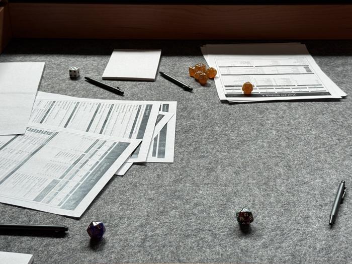 Character sheets and dice on the battle table
