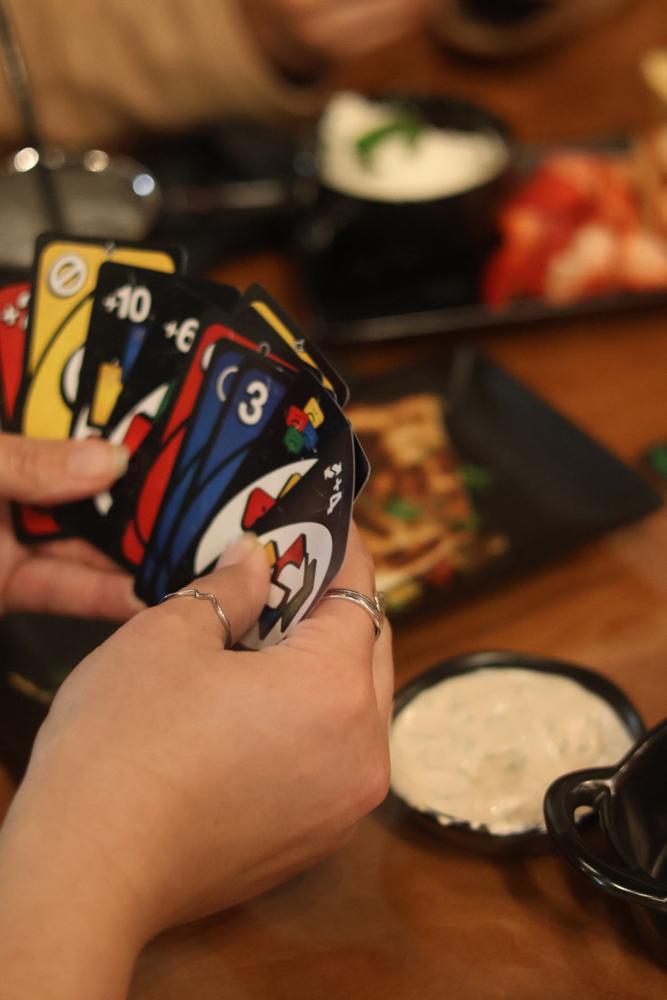 A hand of cards next to shared plates