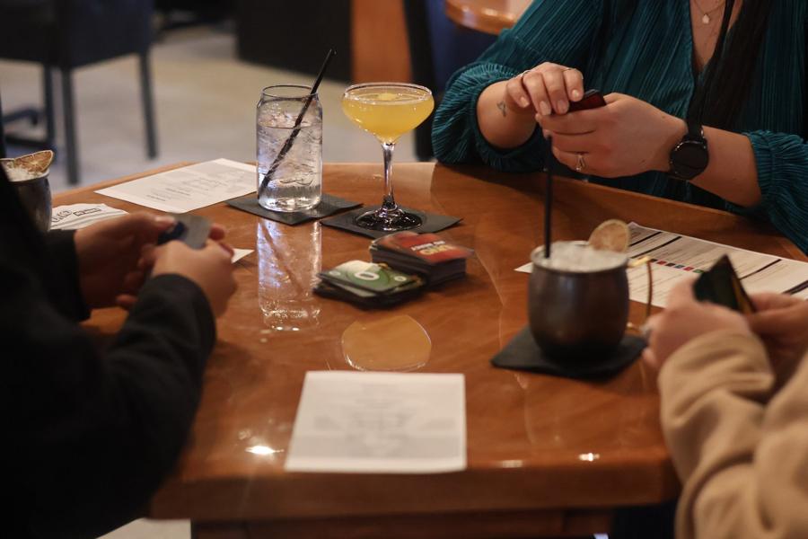 Friends playing a card game over cocktails at the Vault